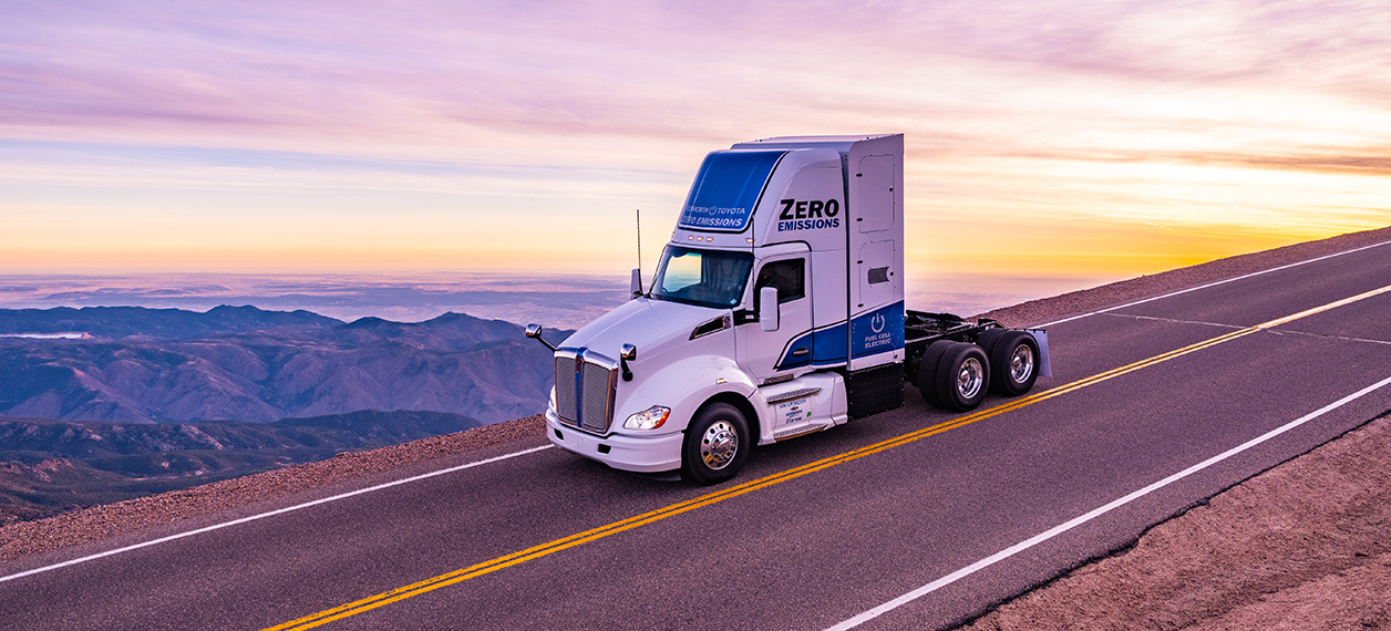 Kenworth zero emission truck driving on the highway during sunrise