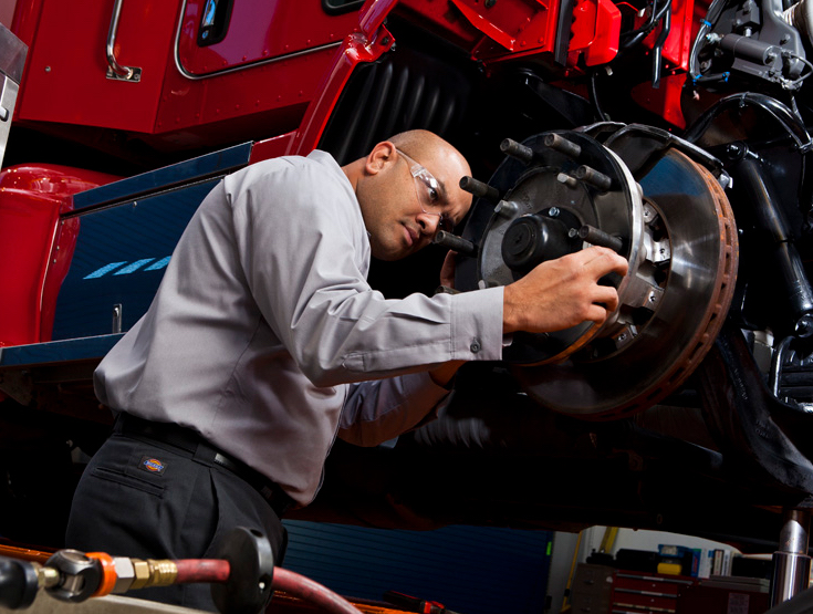 Kenworth mechanic inspecting brakes